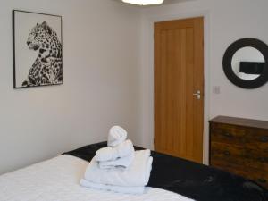 a bedroom with a bed with towels on it at Old Colliery Cottage in Shilbottle