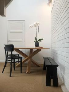 a wooden table with a plant and a bench in a room at Rustig logeerverblijf aan de rand van de stad in Lekkum