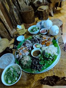 a table with a green plate of food on it at Homestay duy mạnh gần suối nước khoáng nóng trạm tấu in Cham Ta Lao
