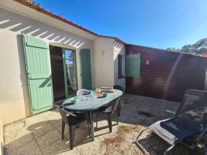 a patio with a table and chairs in front of a house at Maison Saint-Jean-de-Monts, 3 pièces, 5 personnes - FR-1-224C-125 in Saint-Jean-de-Monts