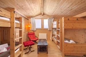 a room with bunk beds and a table and a chair at Chalet Gentil Family friendly Mountain getaway in Riddes