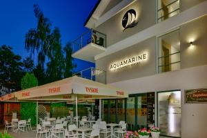 a building with tables and chairs in front of it at Aquamarine Mielno in Mielno
