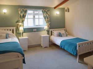 a bedroom with two beds and a window at Blueberry Cottage in Bedfield