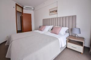 ein Schlafzimmer mit einem großen weißen Bett mit rosa Kissen in der Unterkunft Magnolia Place in Tivat