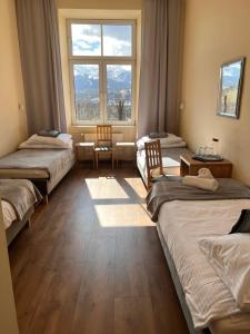 a room with three beds and a large window at Nauczycielskie Centrum in Zakopane
