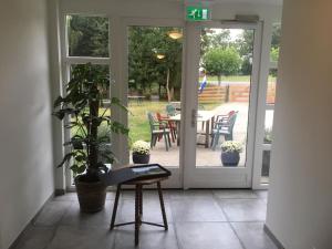 an open door to a patio with a table and a plant at Private apartment - Green Heart center NL in Woerden