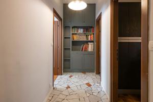 einen Flur mit grünen Schränken und einem Bücherregal in der Unterkunft [Cozy apartment] Treviso 31 in Mailand