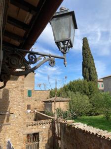 a street light hanging from a wall with a tree at Casa Vacanze Mary in Orvieto