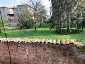 a stone wall with a green field and trees at Casa Vacanze Mary in Orvieto