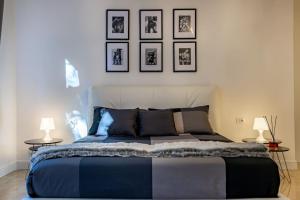 a bedroom with a bed with four pictures on the wall at San Babila - Luxury Milanese Apartment in Milan