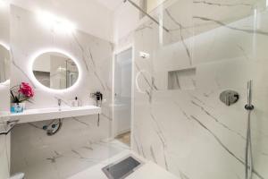 un bagno bianco con doccia e lavandino di San Babila - Luxury Milanese Apartment a Milano Altre 50 foto
