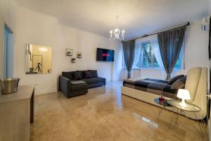 uma grande sala de estar com uma cama e um sofá em San Babila - Luxury Milanese Apartment em Milão