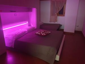 a bedroom with a bed with a pink light on it at B&B da FRANCESCO Locazione Turistica in Ruvo di Puglia