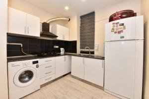 a kitchen with white cabinets and a washer and dryer at SVM SUİTES in Istanbul