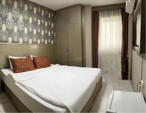 a bedroom with a large white bed with brown pillows at Metro Otel in İzmir +12 photos