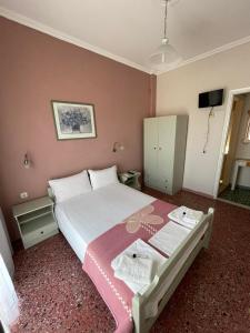 アスプロヴァルタにあるHotel Angelaのピンクの壁のベッドルーム1室(大型ベッド1台付)