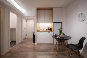 a kitchen with white cabinets and a table and chairs at Plaka With Acropolis Rooftop View Access in Athens