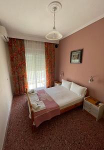sypialnia z łóżkiem i oknem w obiekcie Hotel Angela w mieście Asprovalta