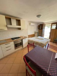 una cucina con tavolo e un letto in una camera di Appartamenti Martini - Tirrenia a Pisa