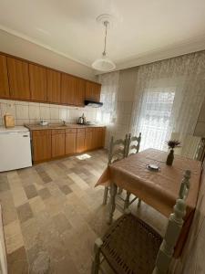 a kitchen with a wooden table and a kitchen with a refrigerator at Hotel Angela in Asprovalta