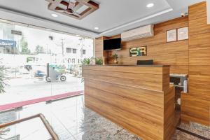 a lobby with a wood paneled wall with a reception desk at Capital O Safari Rooms Near Snow City in Bangalore