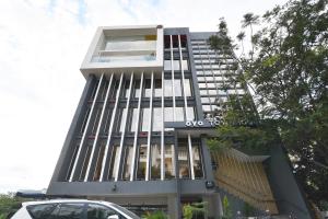 a building with a car parked in front of it at Super Townhouse Spruce Hotels Bellandur in Bengaluru