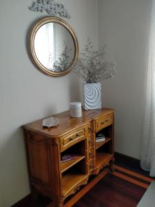 um armário de madeira com um espelho na parede em Haz de mi Rincón en Mugardos tu experiencia. em Mugardos