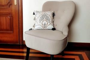 uma cadeira branca com uma almofada num quarto em Haz de mi Rincón en Mugardos tu experiencia. em Mugardos