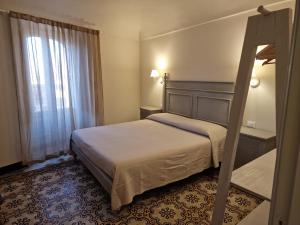una camera d'albergo con letto e finestra di B&B L'Orto Sul Tetto a Ragusa