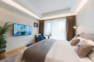 広州市にあるLivetour Hotel Financial City Kehui Road Metro Guangzhouのベッドルーム1室(大型ベッド1台、壁掛けテレビ付)