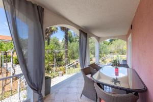 une pièce avec une table et des chaises sur un balcon dans l'établissement Apartman Ponte Mohito, à Punat