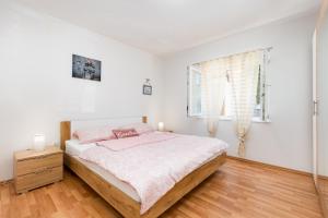 une chambre blanche avec un lit et une fenêtre dans l'établissement Apartman Ponte Mohito, à Punat