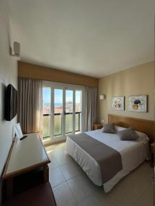 a bedroom with a large bed and a large window at Hotel Albatros in Gandía