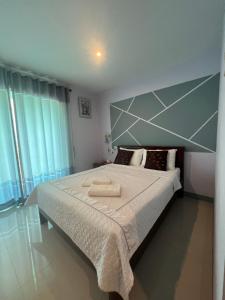 a bedroom with a large bed with two towels on it at zzeehouse in Ao Nang Beach