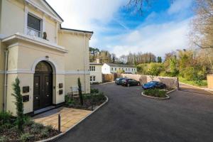 a house with a driveway with cars parked in it at Stylish Sea View Apartment in Torquay