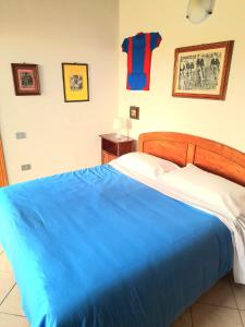 a bedroom with a bed with a blue blanket at San Martino - Casa Landi in Castellina in Chianti