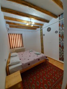1 dormitorio con 1 cama y alfombra roja en KHIVA ABDULLA Guest House, en Khiva