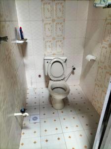 a bathroom with a toilet with a tiled floor at Kikambala Eco Villas in Mombasa