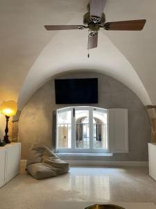 La casa sul Cortile في سيراكوزا: غرفة معيشة مع مروحة سقف ونافذة