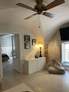 La casa sul Cortile في سيراكوزا: غرفة معيشة مع مروحة سقف وطاولة مع مصباح