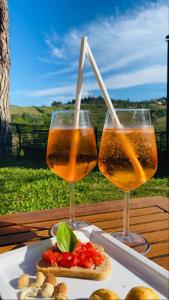 two wine glasses sitting on a table with food at Le Mandrie di Ripalta in Montespertoli