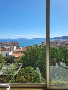 a view of the ocean from a window at Maison centre ville vue mer in Le Lavandou