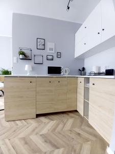 eine Küche mit weißen Wänden und Holzschränken in der Unterkunft Studio Gruszka in Gdynia