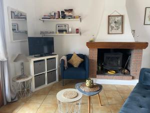 a living room with a blue couch and a fireplace at Iris, les Gîtes de Carlux in Carlux