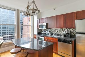 a kitchen with wooden cabinets and a counter top at Loop 2BR w Gym Doorman same block as L CHI-674 in Chicago