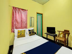 - une chambre avec un lit et un bureau avec un ordinateur dans l'établissement SPOT ON 92414 Hotel Pereng Sari, à Kopeng