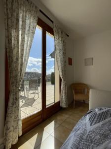 a bedroom with a bed and a large glass door at Iris, les Gîtes de Carlux in Carlux