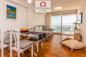 a living room with a dining room table with a view of the ocean at La Belle Mer Palamós in Palamós