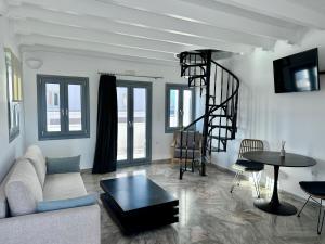 a living room with a couch and a spiral staircase at Oia Captain's Villa in Oia