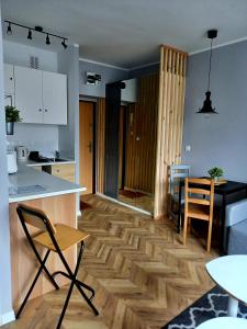 a kitchen and living room with a wooden floor at Studio Gruszka in Gdynia